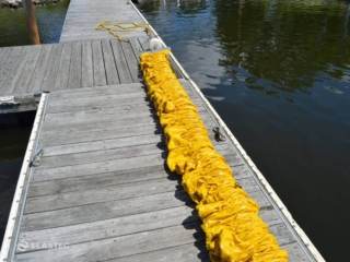 Compactible boom on dock