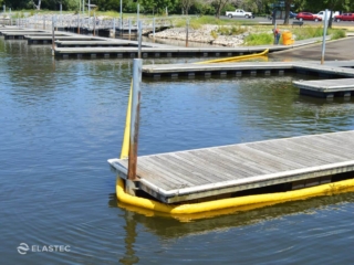 Elastec compactible oil boom around boat dock