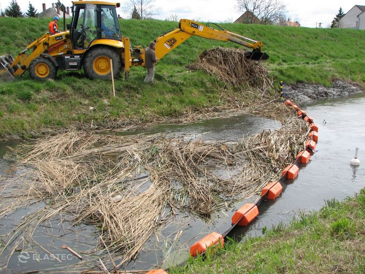 PermaFence containment boom in creek stopping floating debris