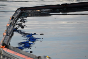 Inflatable floating boom containing oil