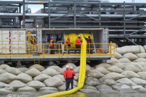 Self-inflated containment boom in container