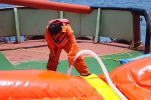 Worker inflating oil boom