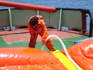 Worker inflating oil boom