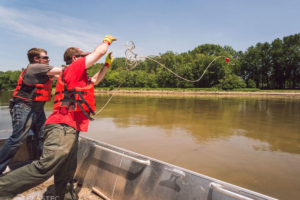 Throwing grapple hook for oil containment boom