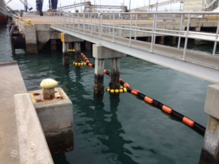 Containment boom tether system on pier