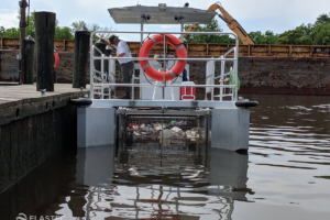 Barco retirando lixo do cais