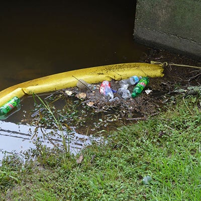 Boom de garrafa com lixo e detritos