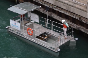 Omni Catamaran écumant les déchets le long d'un quai