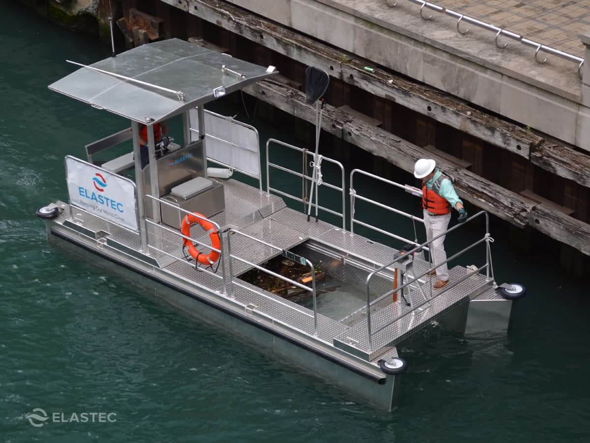 Omni Catamaran skimming trash along the side of a dock