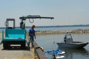 Portador de orugas bajando el skimmer de vertedero al agua