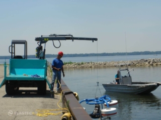 Crawler carrier lowering weir skimmer into water