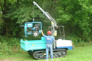 Multi-purpose carrier lowering hydraulic power unit into bed