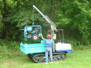 Multi-purpose carrier lowering hydraulic power unit into bed